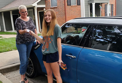 girl receiving auto insurance card